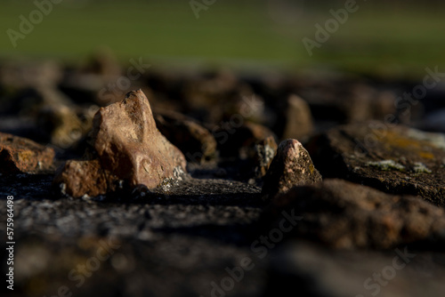 Small rocks found at the Roman defense wall remains embedded in concrete monument on historic archeologic outdoors site.