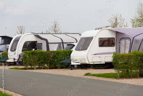 Caravans parked up on Caravan park with small hedges separating them and giving privacy.
