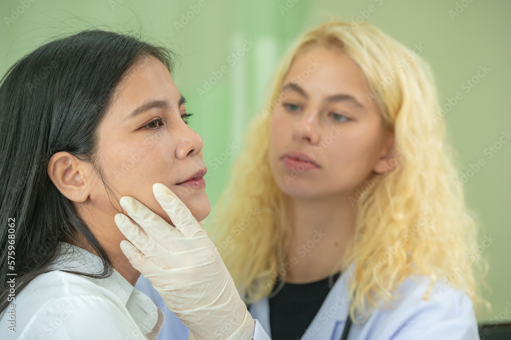 doctors examining patient face skin check before filler botox surgery. Beautician use hand glove touching woman face for diagnosis therapy skin care improvement. doctors examining patient face skin check before filler botox surgery. Beautician use hand glove touching woman face for diagnosis therapy skin care improvement.
