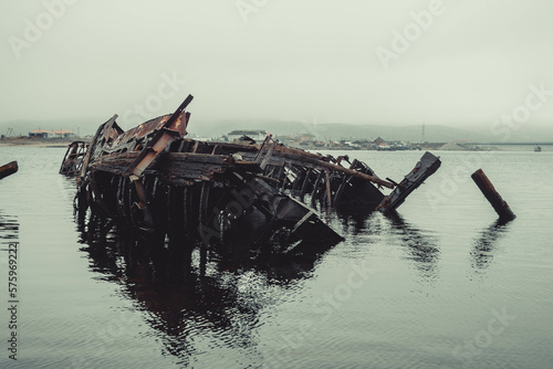 Foto The skeleton of an old ship on the embankment