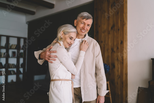 Happy senior couple hugging in room