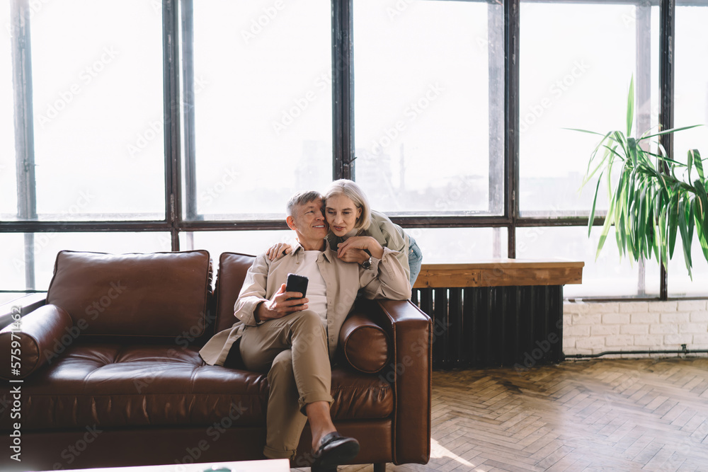Obraz premium Happy couple with smartphone in living room