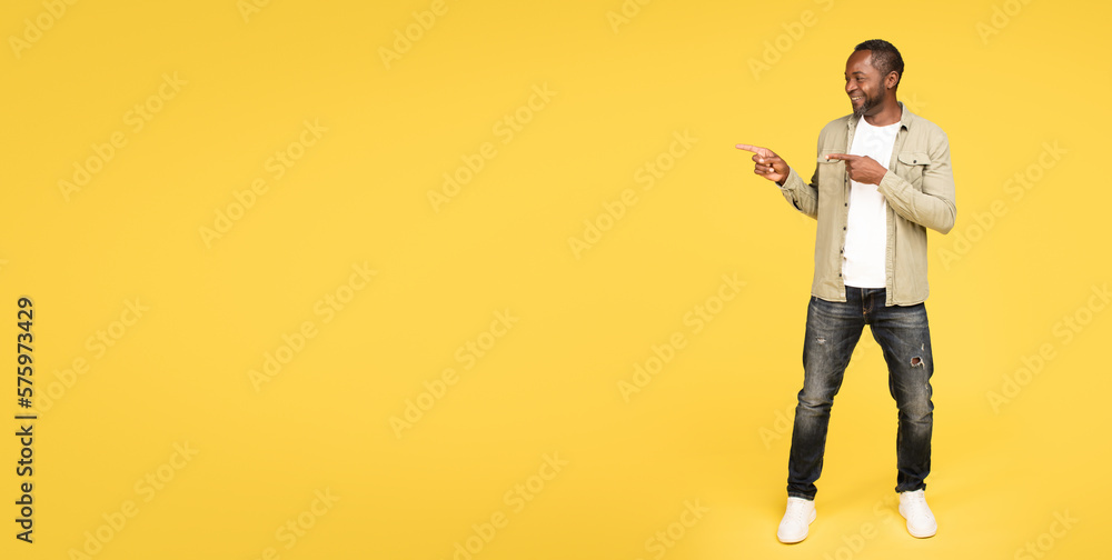 Glad calm mature black male in casual show fingers at empty space, recommend ad and offer