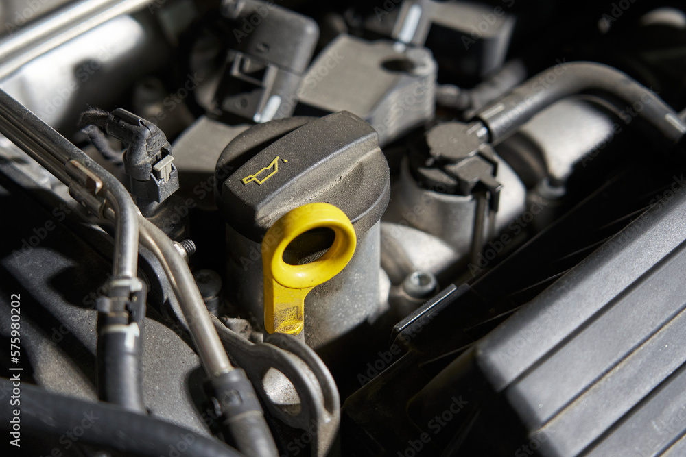 Obraz premium car engine oil filler and yellow dipstick for checking oil level
