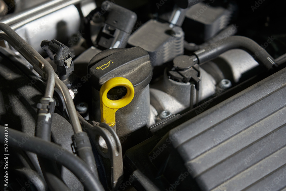 car engine compartment with oil filler neck, oil level dipstick