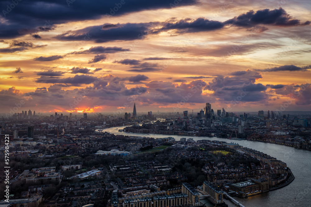 Wide panoramic view of the illuminated, urban skyline of London, England, during a winter sunset