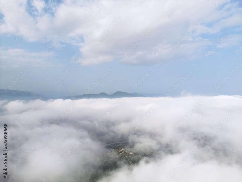 Flying above the clouds on drone.Drone soars through thick clouds, revealing majestic mountain silhouettes. Calp, Alicante, Spain