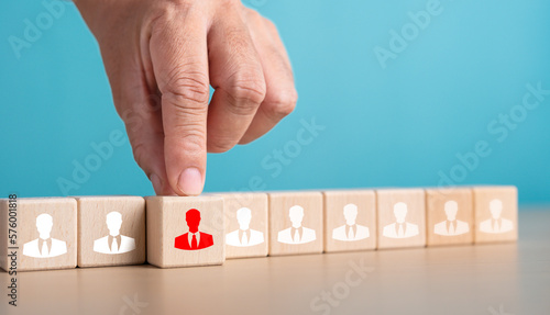 Human resources management and recruitment business build team concept. Close up hand choosing man people icons on wooden cube blocks in horizontal alignment.