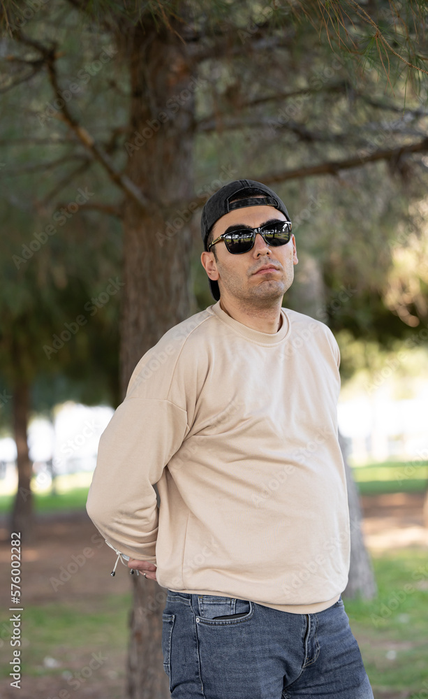 Young man with belly wearing sun glasses in forest. Young man with belly wearing sun glasses in forest.