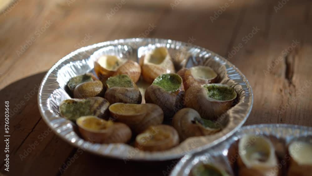 Escargot on wooden table in sunlight outdoors. Close-up delicious meal on sunny spring summer day Escargot on wooden table in sunlight outdoors. Close-up delicious meal on sunny spring summer day