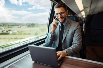 Handsome middle age businessman using his laptop computer while traveling with high-speed train. Modern and fast travel concept.