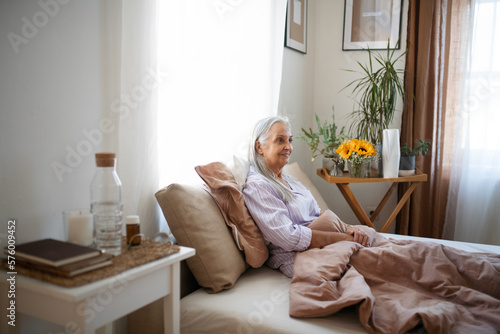 Senior woman resting in her bed during illness.