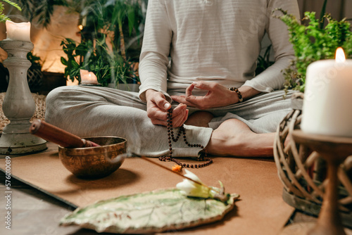 Konstfotografi Close-up of unrecognizable man with rosary meditating with singing bowl and arom
