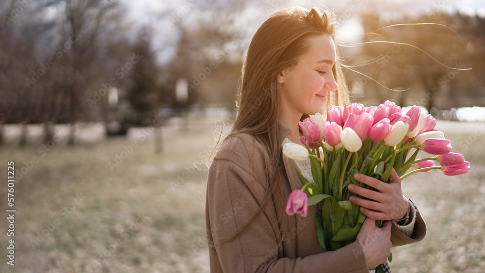 Beautiful girl with tulip flowers in her hands walks in the park Beautiful girl with tulip flowers in her hands walks in the park