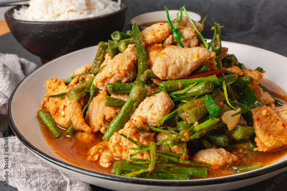 Fototapeta premium Close up, Stir-fried pork and red hot curry paste with or long bean and Ingredients are oyster sauce, fish sauce, sugar, kaffir lime leaves in the dish Eat with cooked rice. Thai cuisine