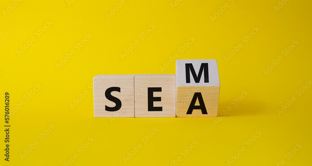 SEM vs SEA symbol. Turned wooden cubes with words SEA and SEM. Beautiful yellow background. Business and SEM vs SEA concept. Copy space SEM vs SEA symbol. Turned wooden cubes with words SEA and SEM. Beautiful yellow background. Business and SEM vs SEA concept. Copy space