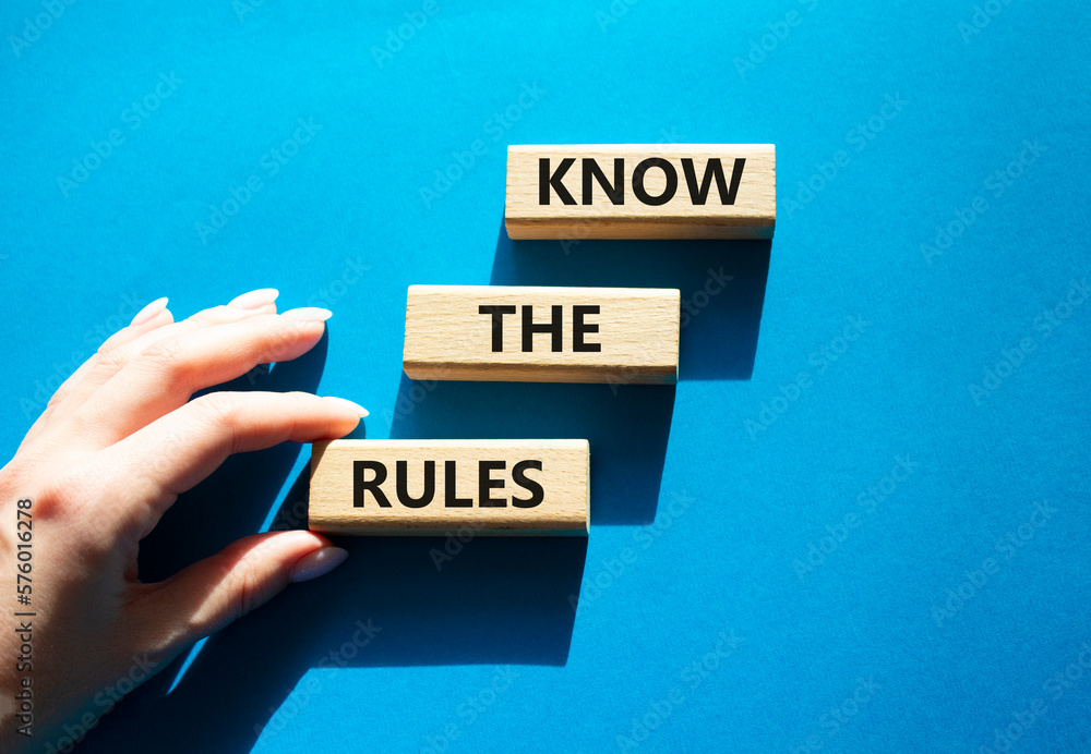 Know the rules symbol. Wooden blocks with words Know the rules. Beautiful blue background. Businessman hand. Business and Know the rules concept. Copy space. Know the rules symbol. Wooden blocks with words Know the rules. Beautiful blue background. Businessman hand. Business and Know the rules concept. Copy space.