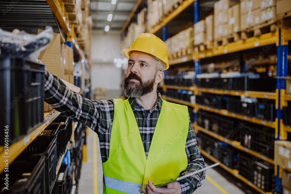 Warehouse worker checking up stuff in a warehouse. Warehouse worker checking up stuff in a warehouse.