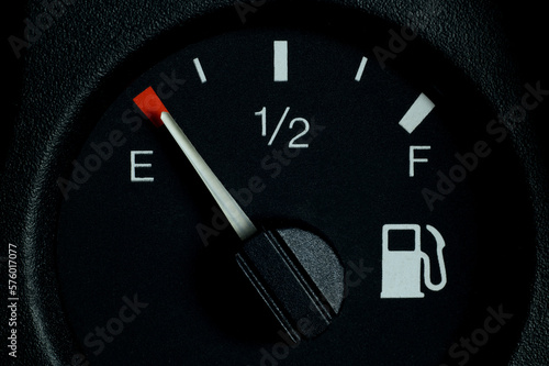 Close-up of a car dashboard, low fuel indicator on the dashboard in an empty car tank.