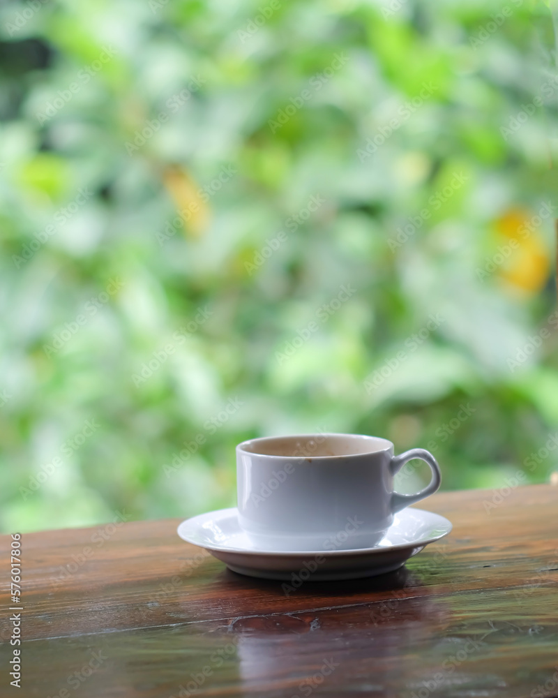 cup of coffee and toasted bread on the wooden table with a garden view cup of coffee and toasted bread on the wooden table with a garden view