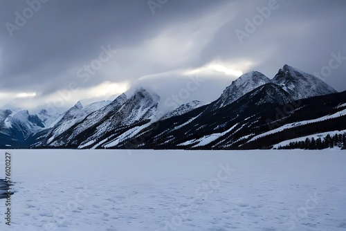 A snowy mountain range with a lake surrounded by snow covered mountains in the foreground and a cloudy sky in the background, with a few clouds in the foreground. Generative AI