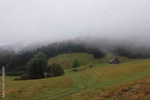 Misty morning in the mountains wiith view to the wooden house in the valley near Neratov, Czech republic photo