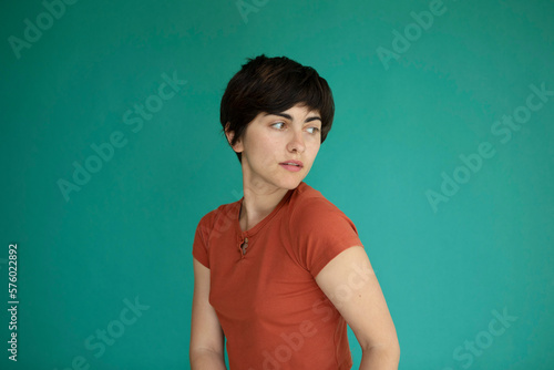 Young woman with short hair against green background photo