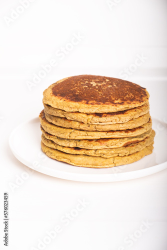 Delicious freshly cooked thick and fluffy gluten free pancakes stacked on white plate. Healthy food. Copy space for text.