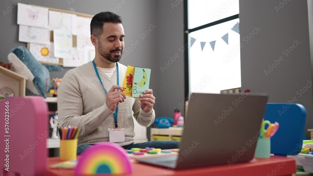 Young hispanic man working as teacher teaching online words lesson at kindergarten Young hispanic man working as teacher teaching online words lesson at kindergarten