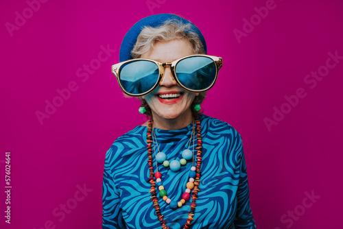 Happy wearing oversized sunglasses against pink background photo