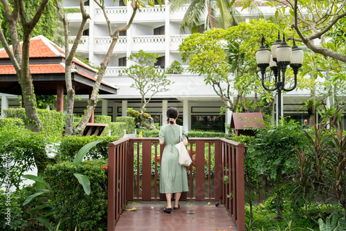 Rear view of woman standing in green garden in tropical area