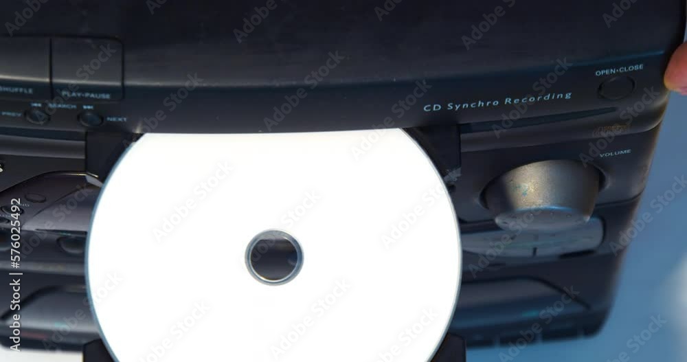 Hand removes the disc from the player.