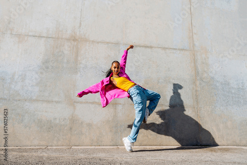 Young hip hop dancer dancing in front of wall photo