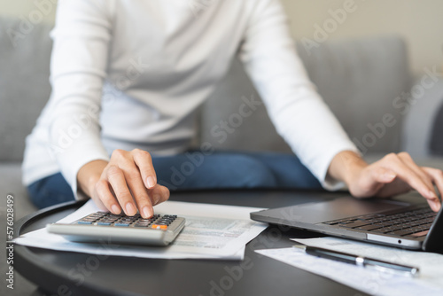 Deduction planning online asian young woman hand using calculator and laptop to calculate balance prepare tax reduction income  cost budget expenses for pay money form personal Individual Income.