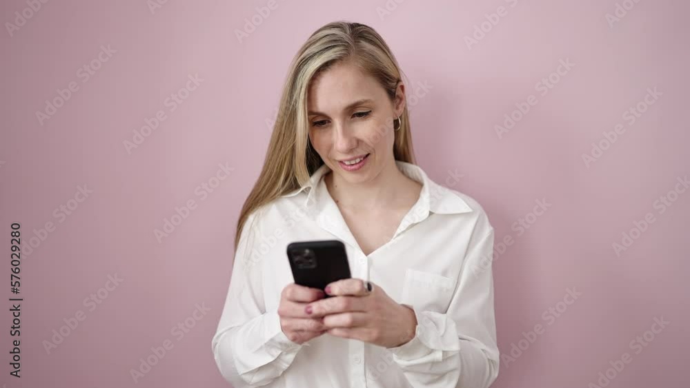 Young blonde woman using smartphone standing over isolated pink background Young blonde woman using smartphone standing over isolated pink background