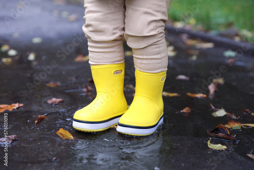 Little girl standing in puddle outdoors, closeup