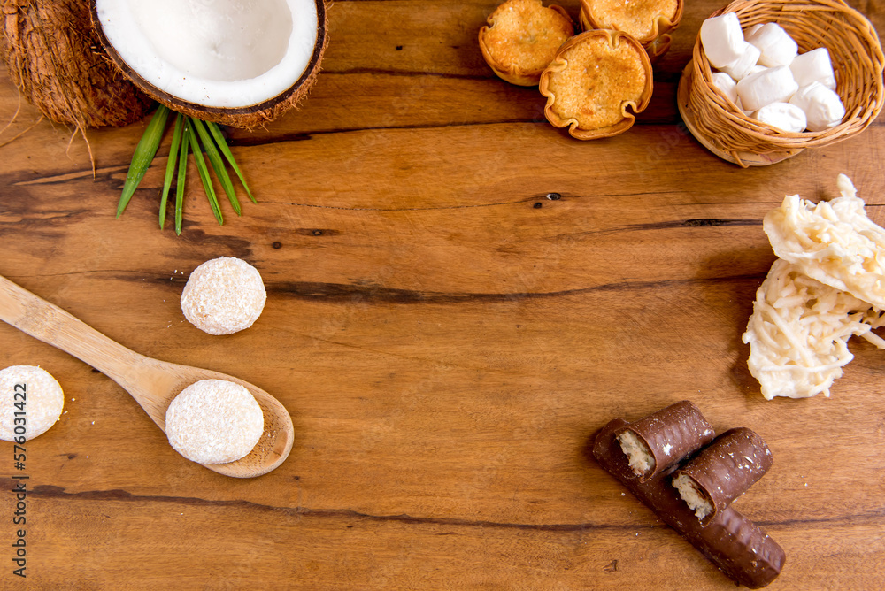Coconut sweets on a wooden table, coconut, coconut candy, chocolate coconut, cocada and beijinho Coconut sweets on a wooden table, coconut, coconut candy, chocolate coconut, cocada and beijinho