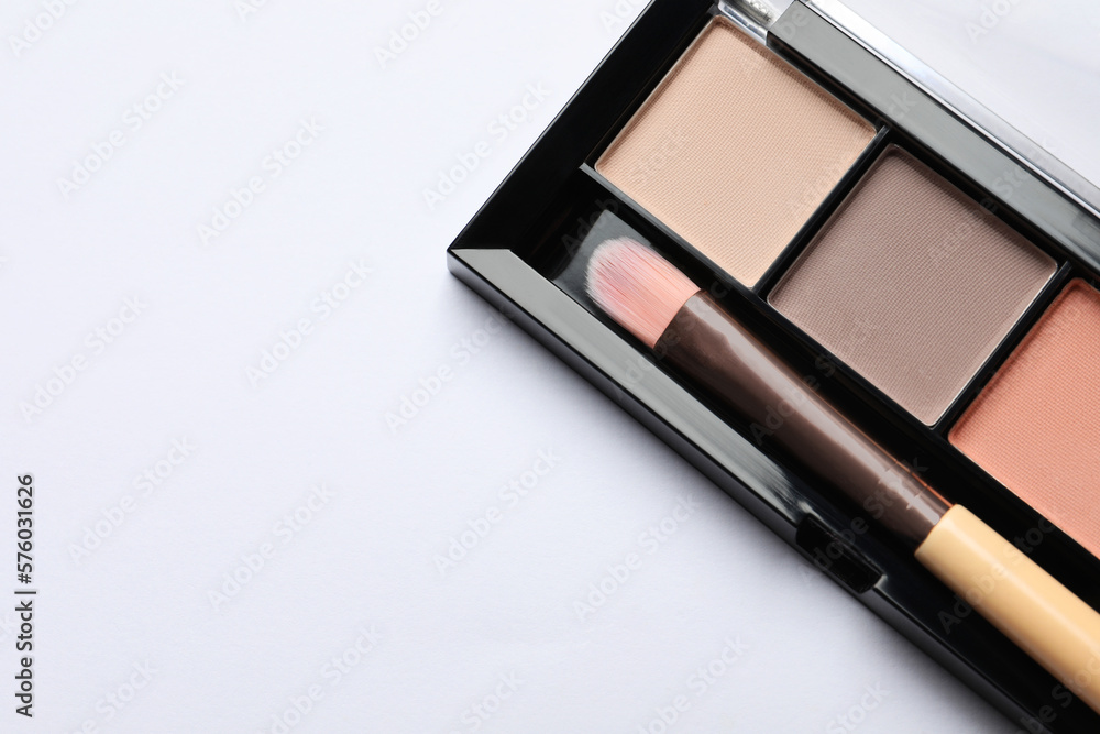 Beautiful eye shadow palette with brush on white table, top view. Space for text Beautiful eye shadow palette with brush on white table, top view. Space for text
