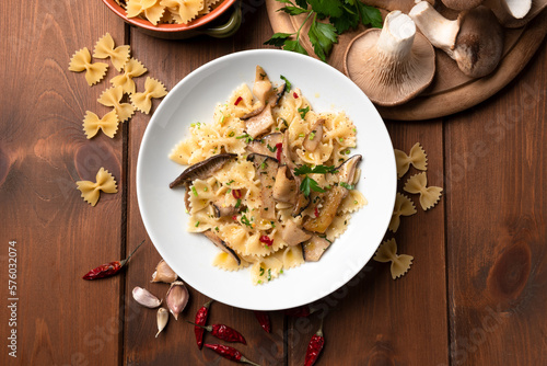 Piatto di deliziosa pasta piccante condita con funghi, aglio e prezzemolo, cibo italiano vegetariano 