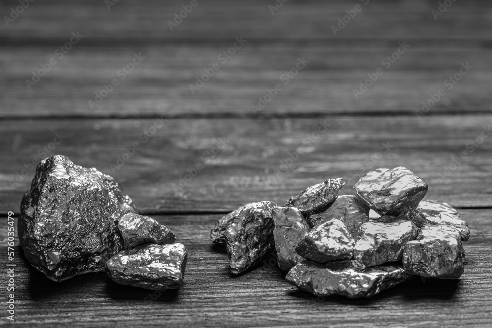 Naklejka premium Pile of silver nuggets on black wooden table. Space for text