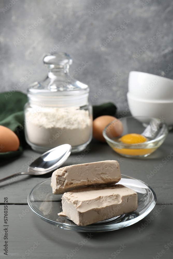 Compressed yeast, eggs and flour on grey wooden table Compressed yeast, eggs and flour on grey wooden table