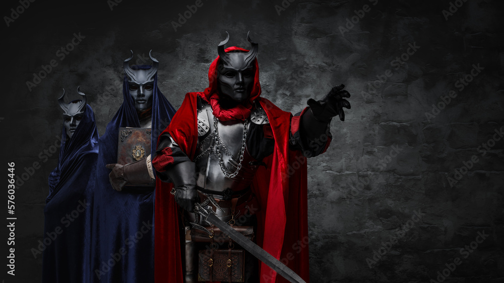 Studio shot of mysterious organization of three cultists dressed in robes and masks.