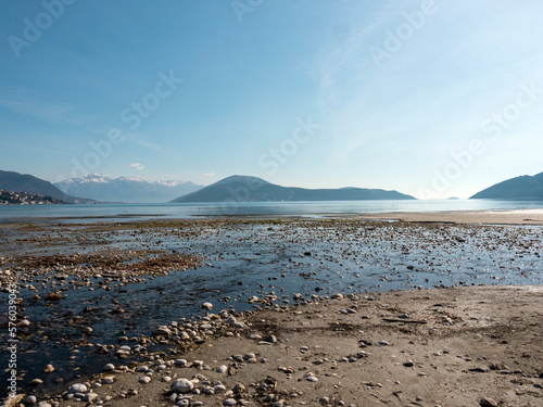 Pebbles and sand during sea low tide with mountains at background