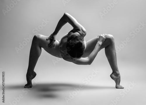 Young gymnast girl stretching and training. Beauty flexible dancer posing in studio photo