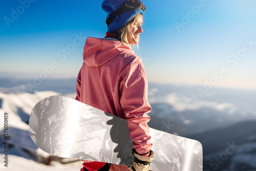 Girl snowboarder stands with snowboard on mountain's top