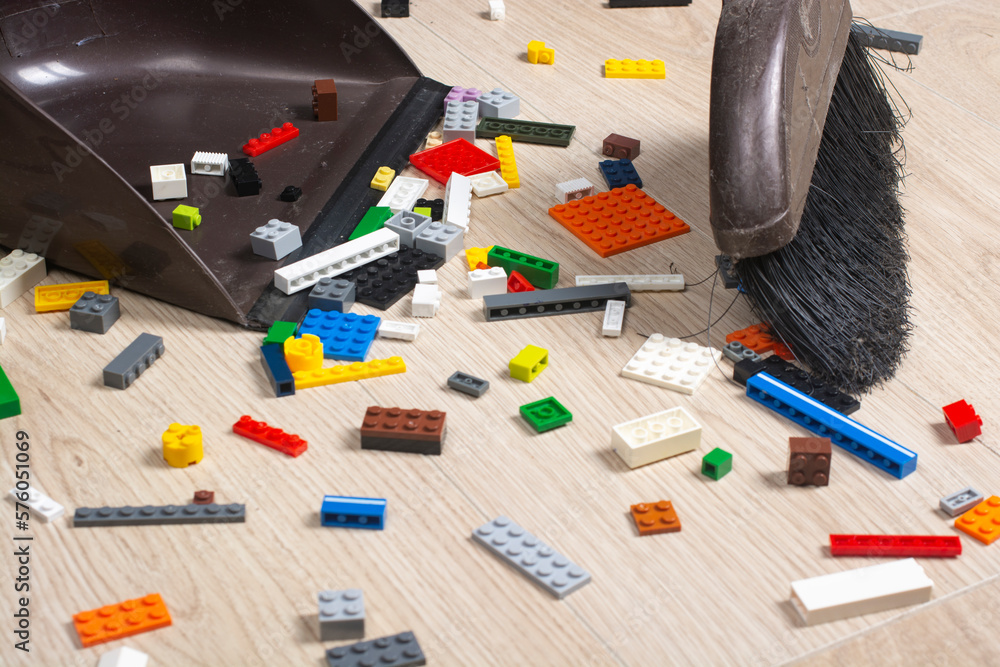 Cleaning of the apartment. Many blocks of different colors of the children's constructor are scattered on the floor. Cleaning of the apartment. Many blocks of different colors of the children's constructor are scattered on the floor.
