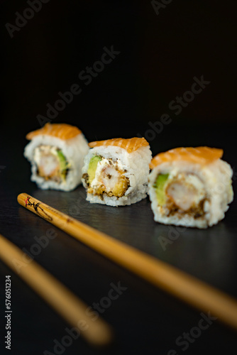 salmon sushi pies. Japanese sushi sticks. black background.