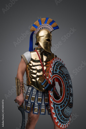 Studio shot of military man from ancient greece with shield and sword.