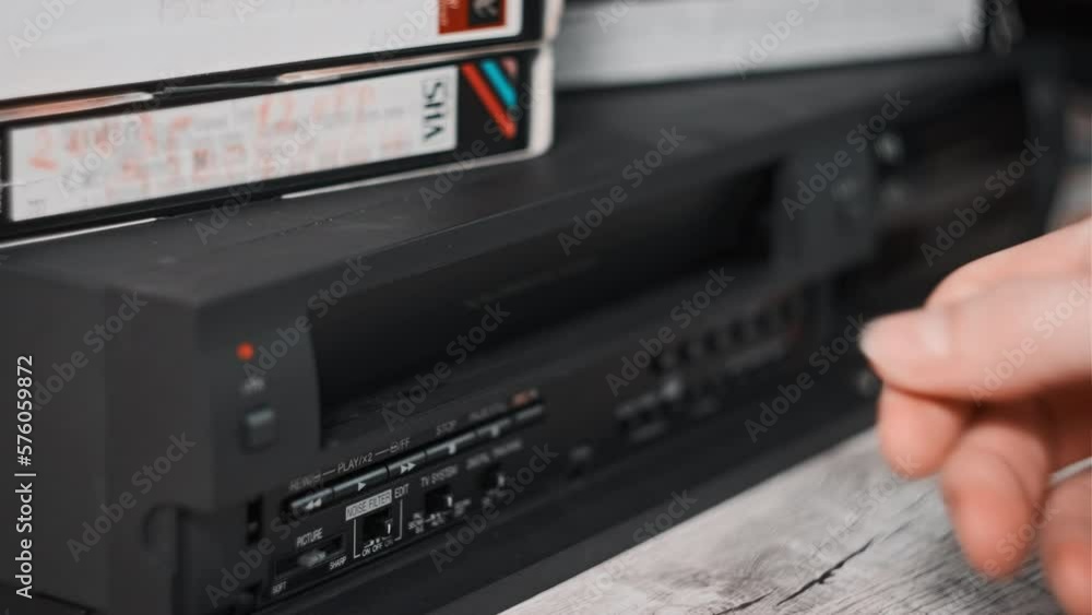 Insert VHS cassette into VCR and push play button. Black vintage