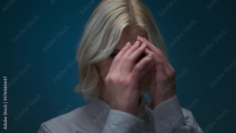 Portrait of blonde woman with bright makeup posing over blue colour wall in studio Portrait of blonde woman with bright makeup posing over blue colour wall in studio